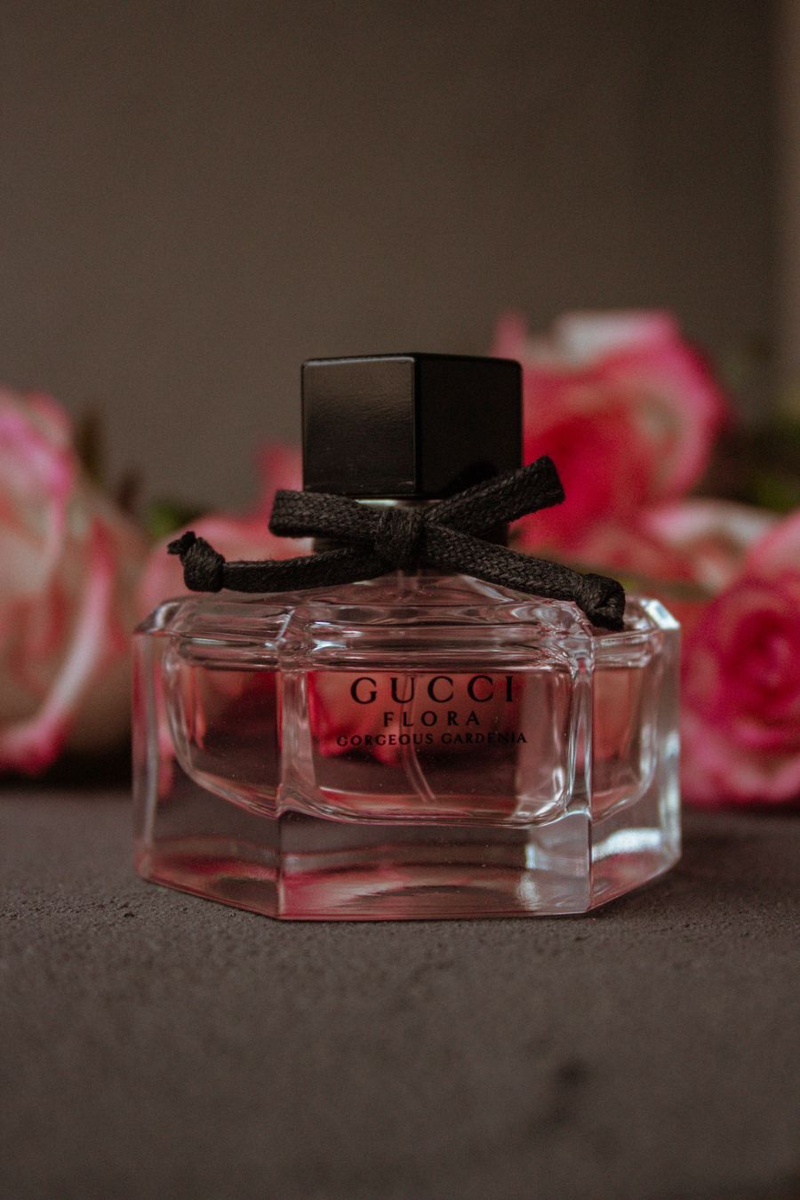Elegant perfume bottle with roses in warm light