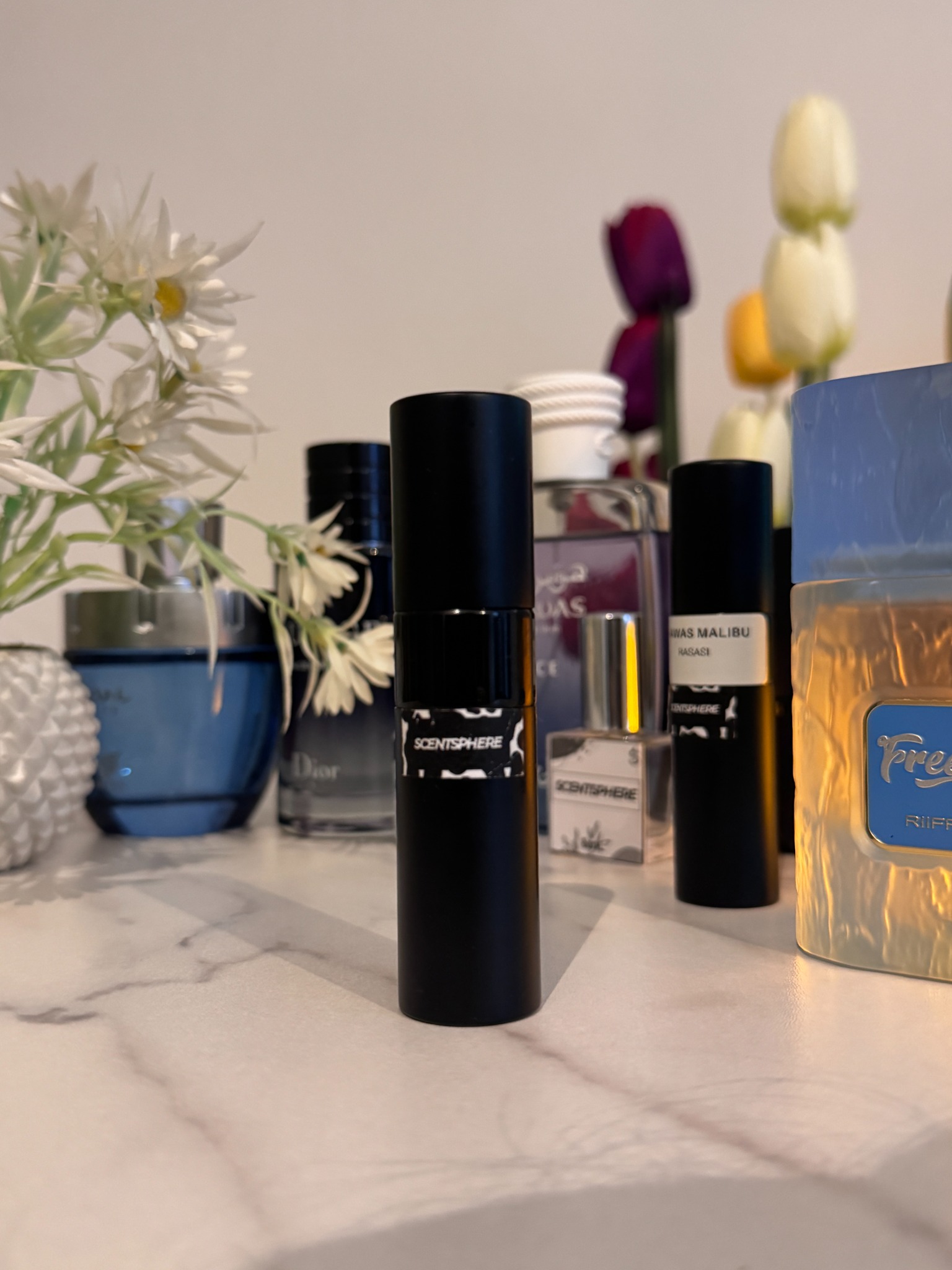 ScentSphere decant bottles displayed with perfumes and flowers